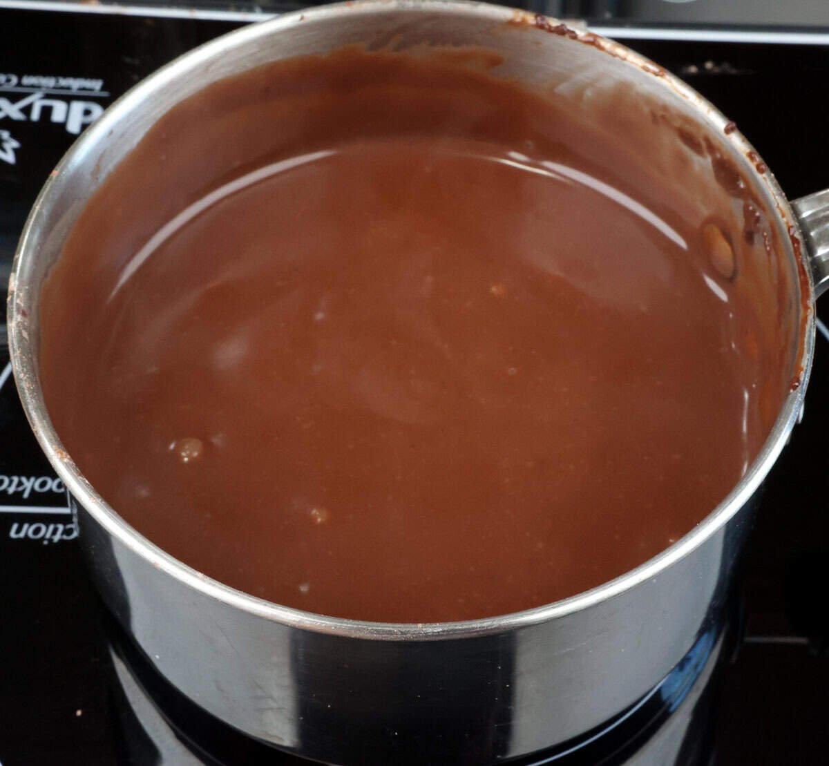chocolate pudding base simmering in a saucepan for a chocolate pie.