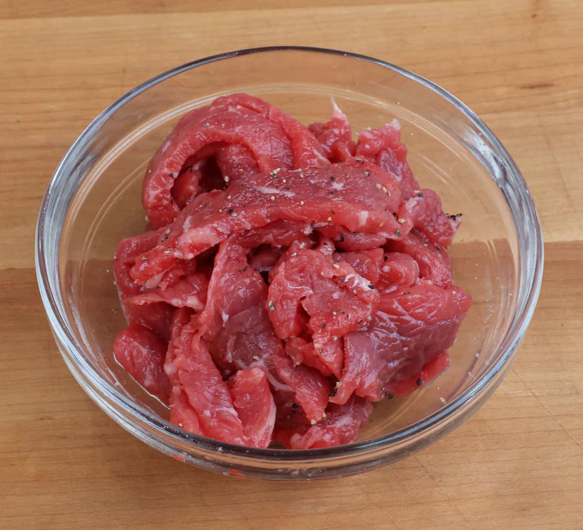 thinly sliced raw steak in a small bowl