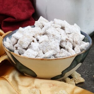 a bowl of puppy chow for one person next to a gold napkin