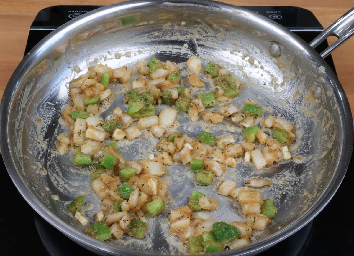 garlic, onions, peppers, and seasonings cooking in a small skillet