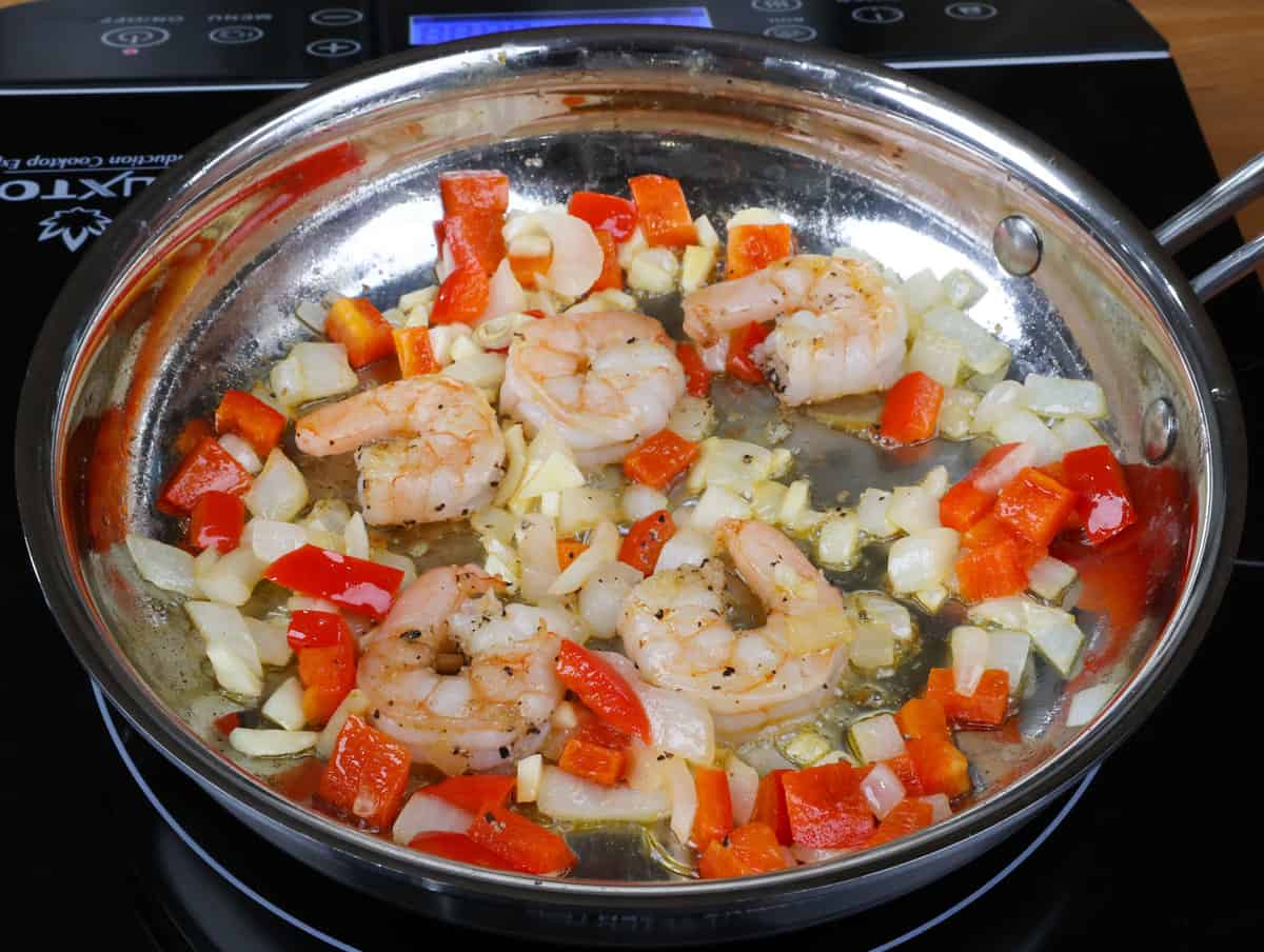 shrimp and vegetables cooking in a small skillet