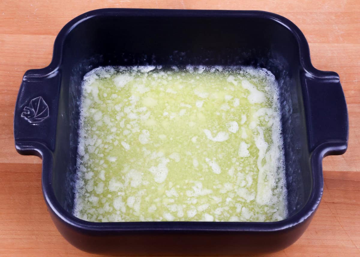 melted butter in the bottom of a square baking dish.