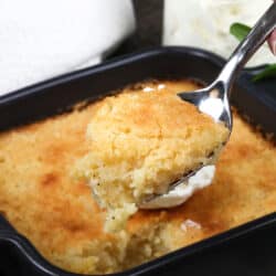 buttermilk pie in a small baking dish with a spoon scooping serving