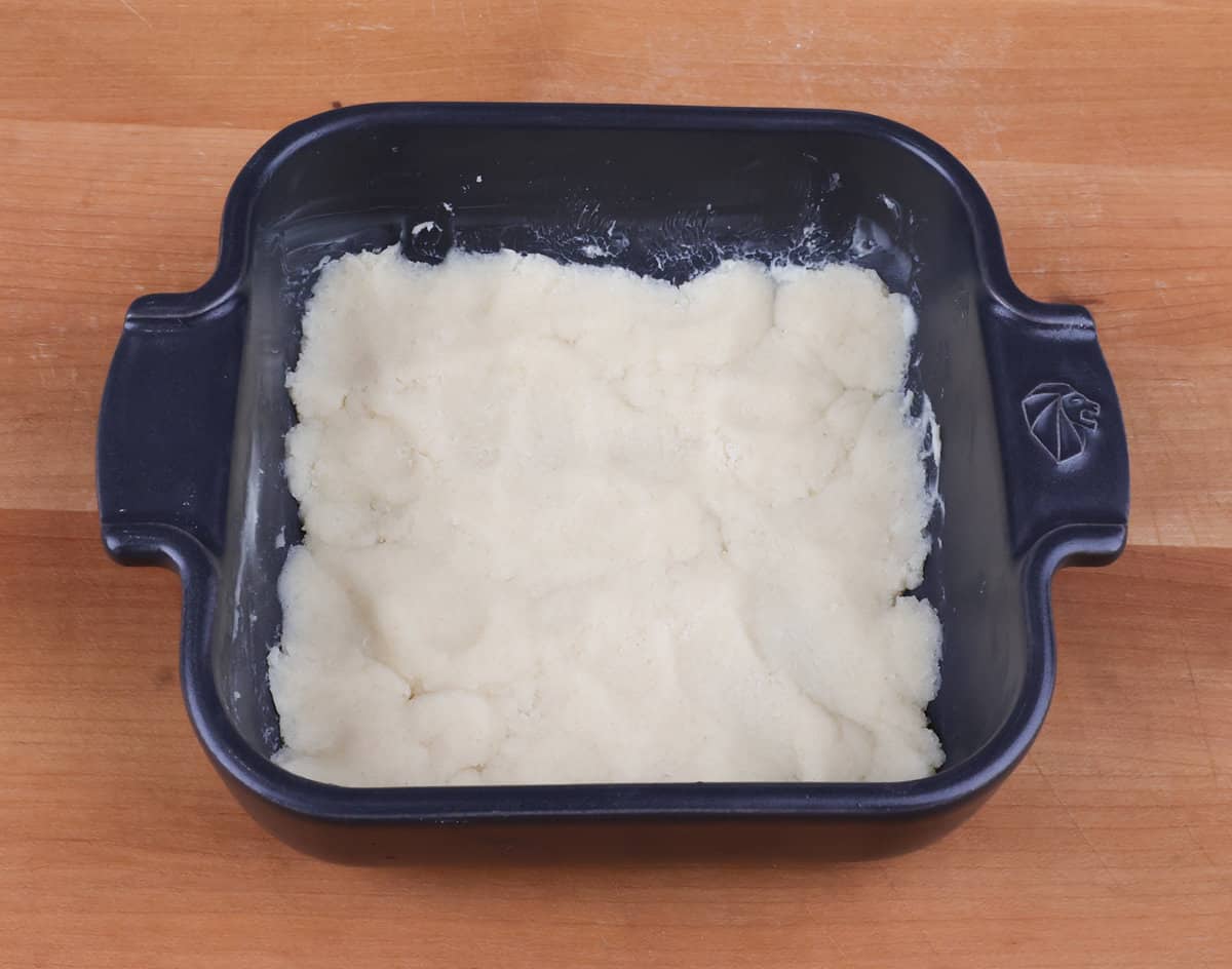 unbaked pie crust in a small square baking dish.