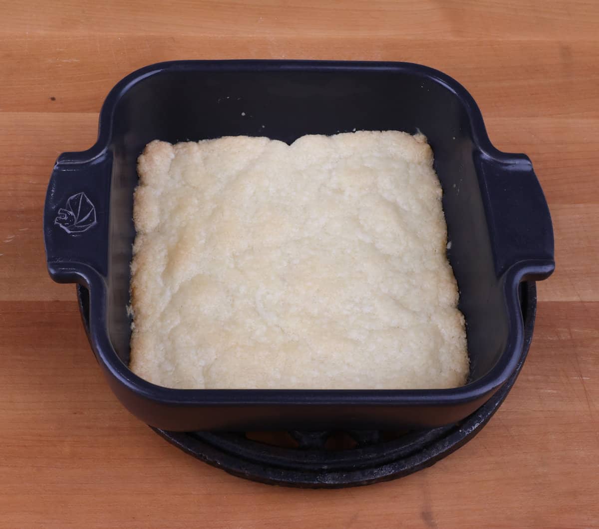 baked shortbread pie crust in a small black baking dish.