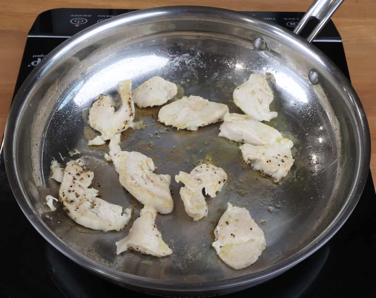 chicken strips cooking in a small skillet.