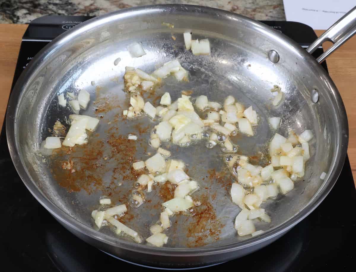 chopped onions and garlic cooking in a skillet