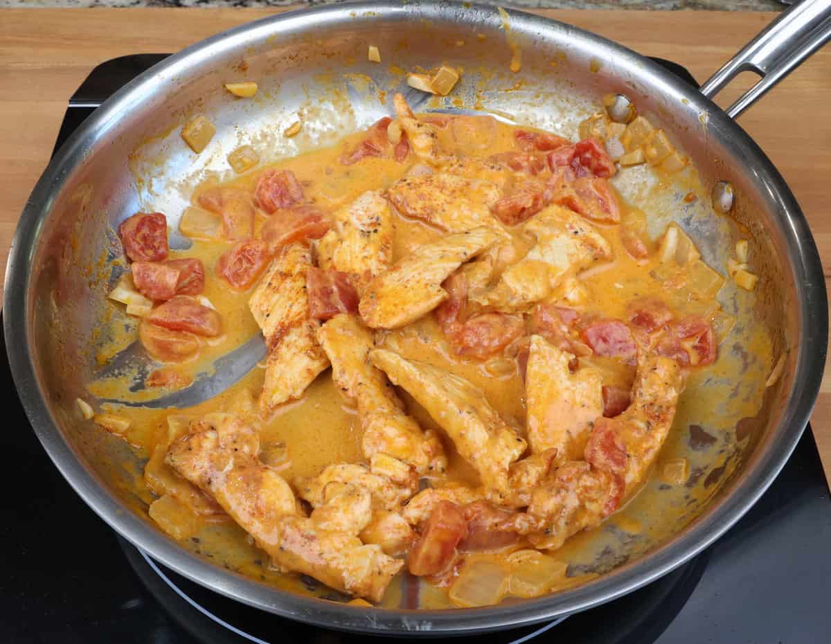 paprika chicken simmering in a skillet.