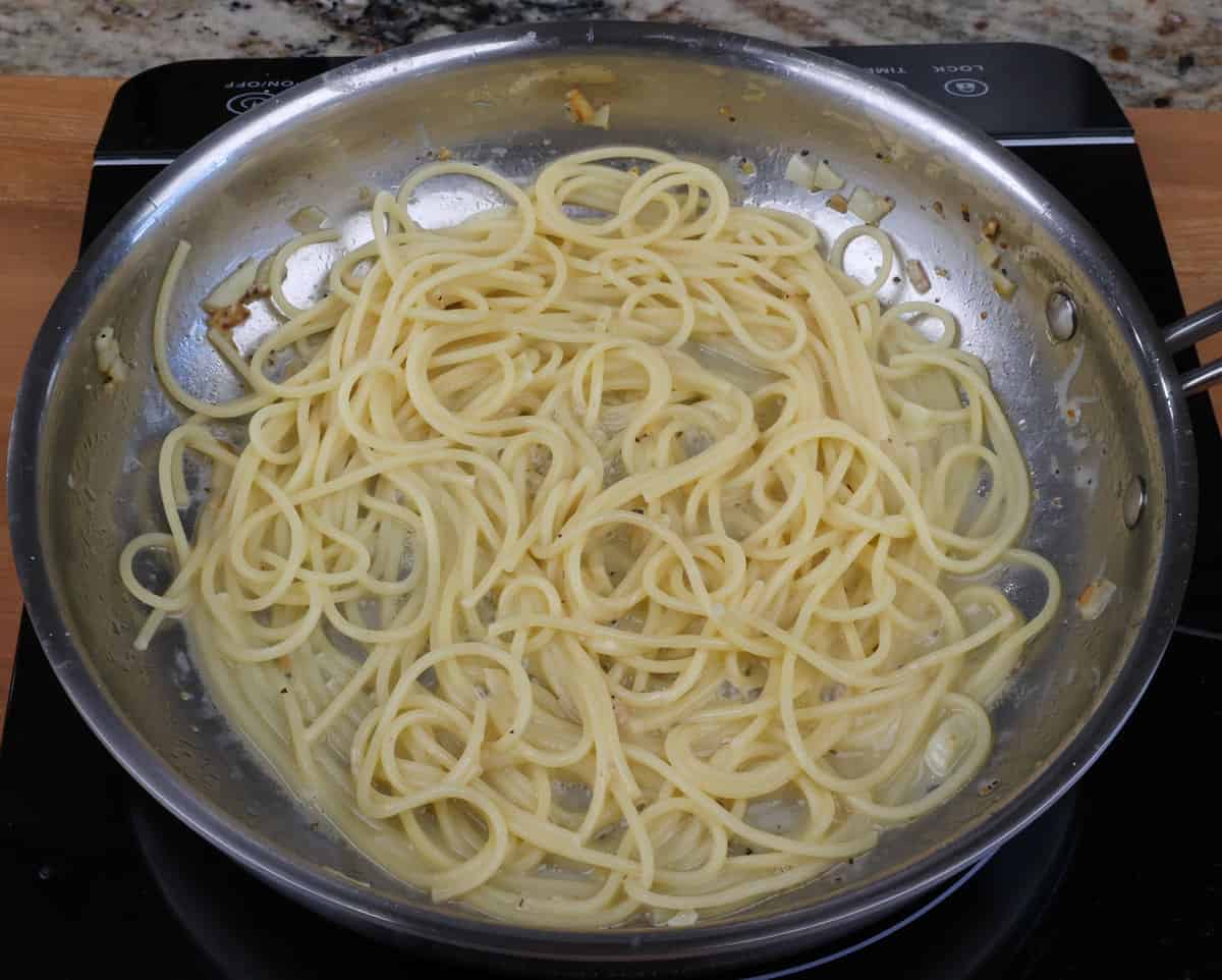 spaghetti with lemon juice and zest in a skillet.