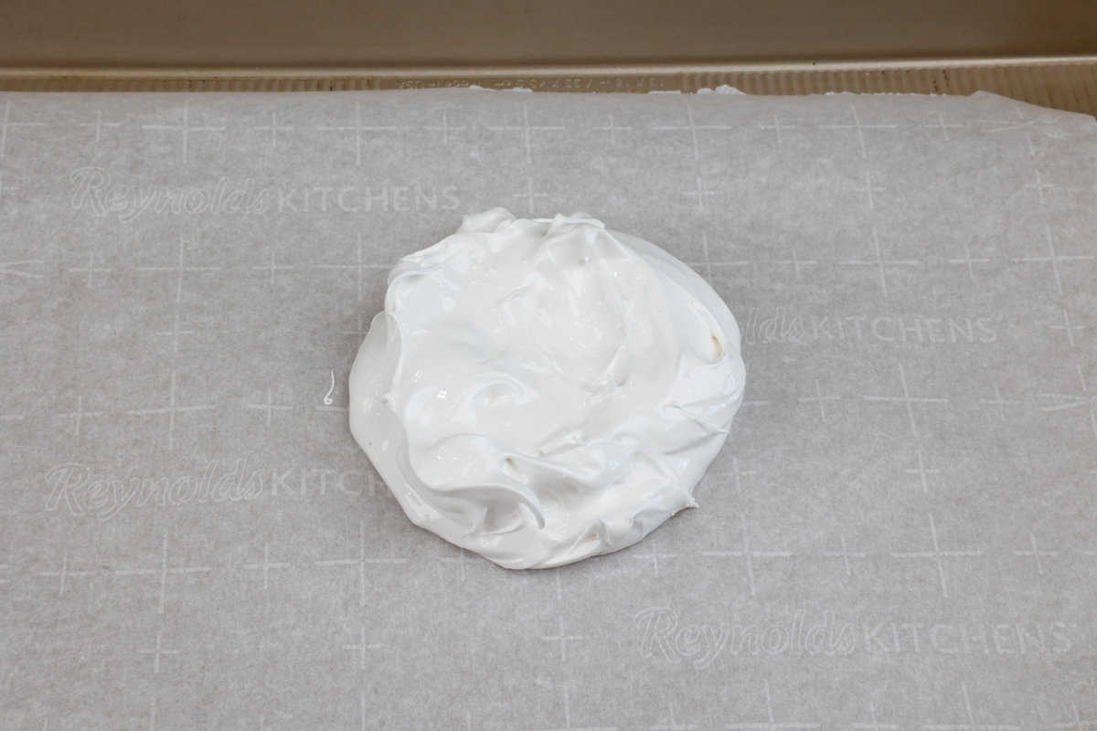one small unbaked pavlova on a parchment paper lined baking sheet