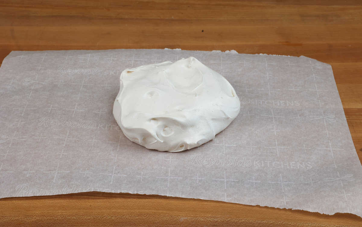 a cooled pavlova on a sheet of parchment paper.
