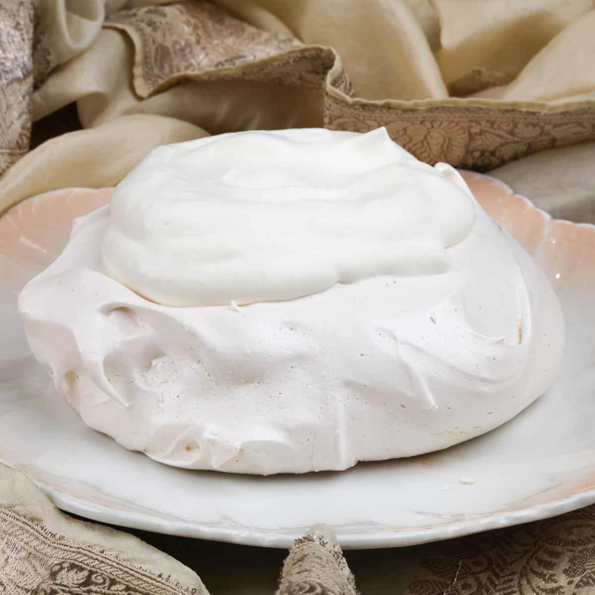 whipped cream on top of a pavlova