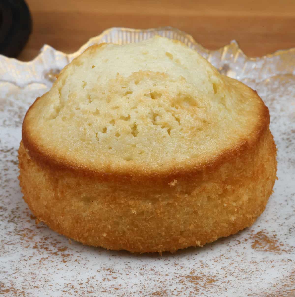 a small white cake on a white and gold plate.