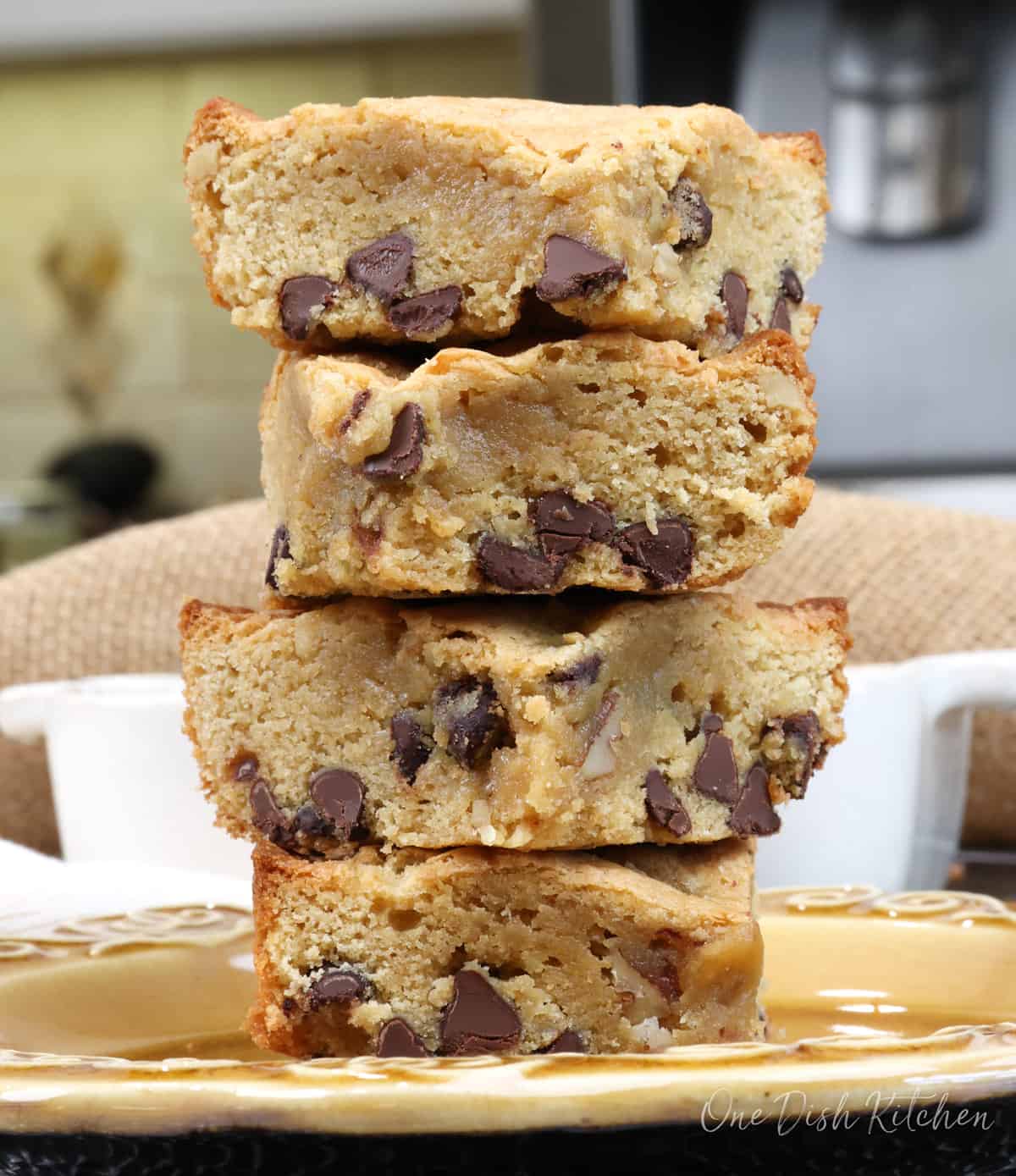 four blondies stacked on top of each other on a brown plate.