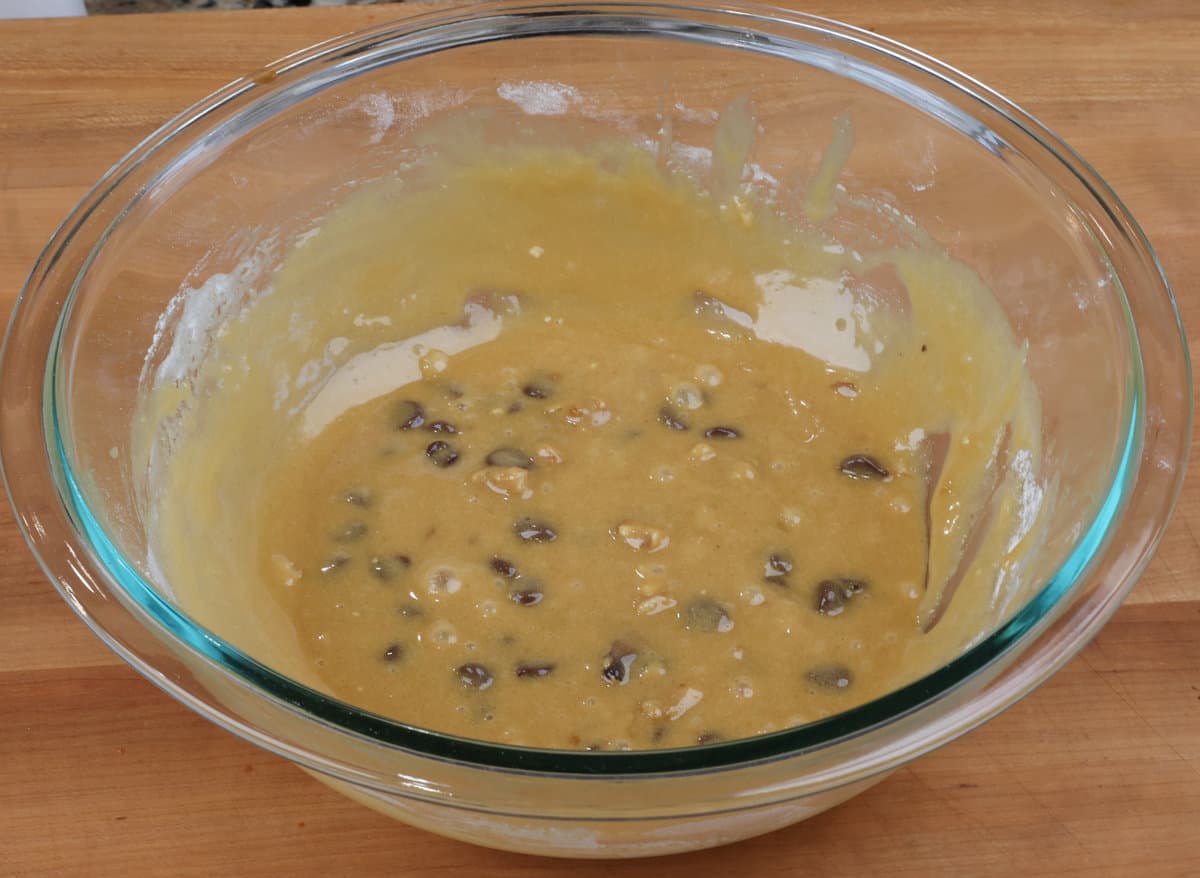 blondie batter in a mixing bowl with chocolate chips and walnuts.