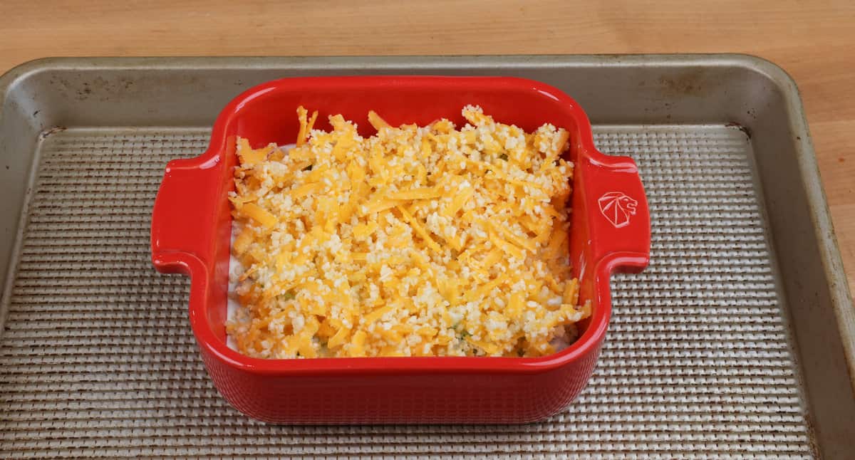 an unbaked small broccoli cheese casserole on a baking sheet.