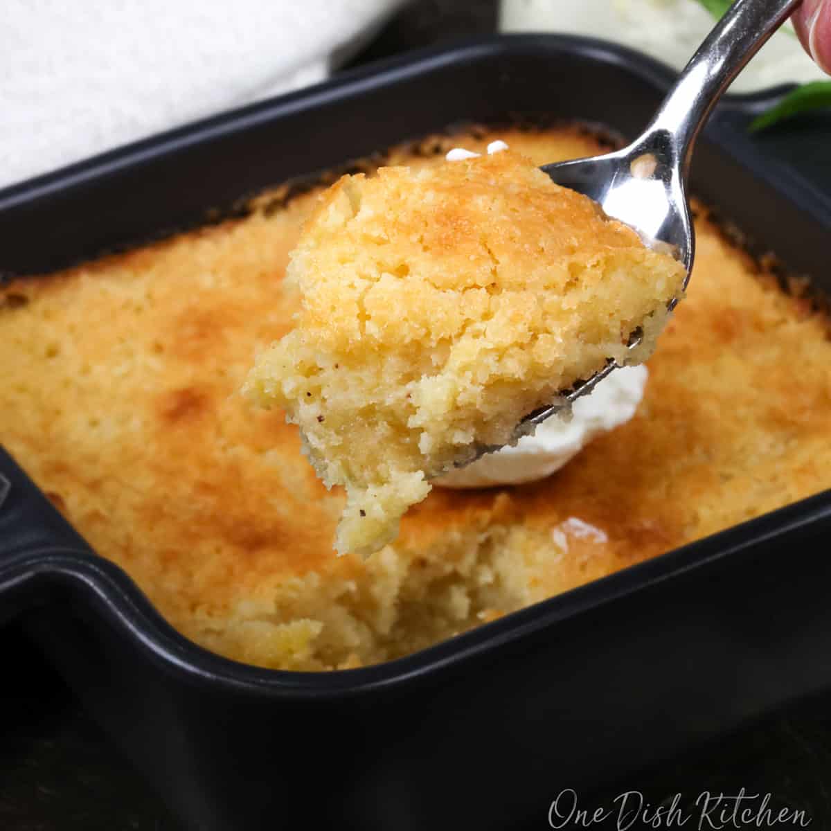 a small buttermilk pie in a square baking dish with a spoon on the side.