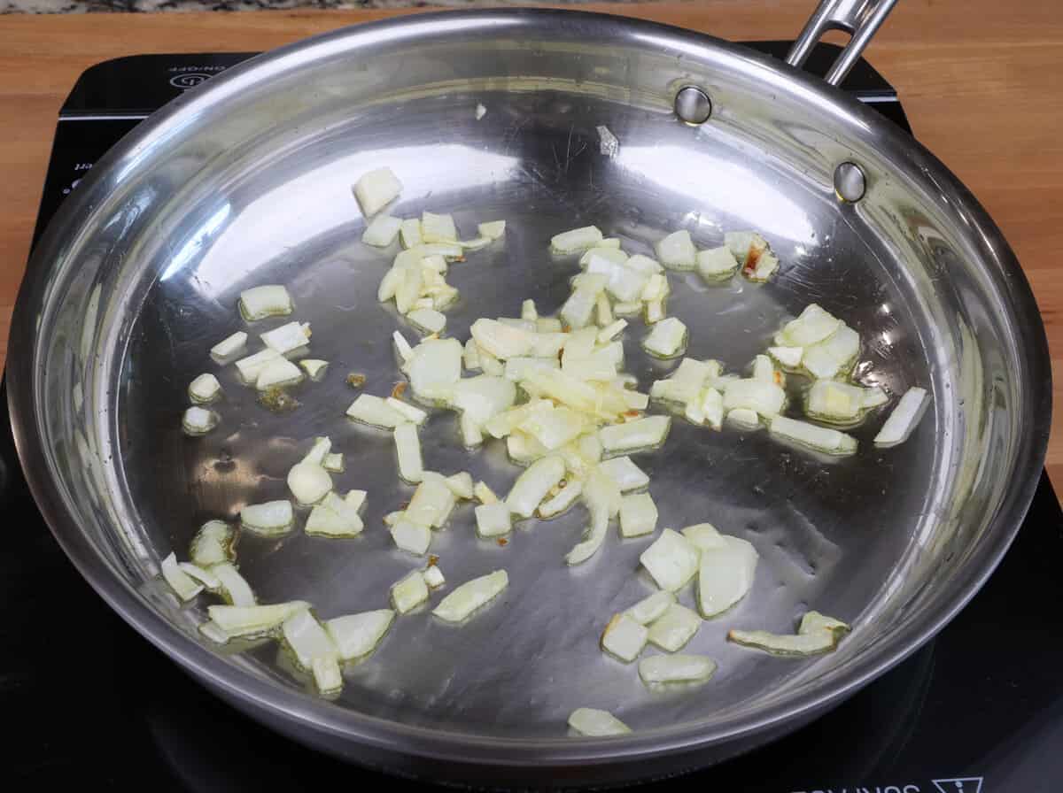 chopped onions and garlic cooking in olive oil in a skillet.