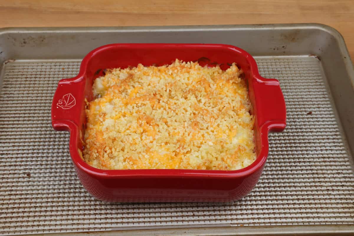 a small batch cheesy potato casserole on a baking sheet cooling on a counter