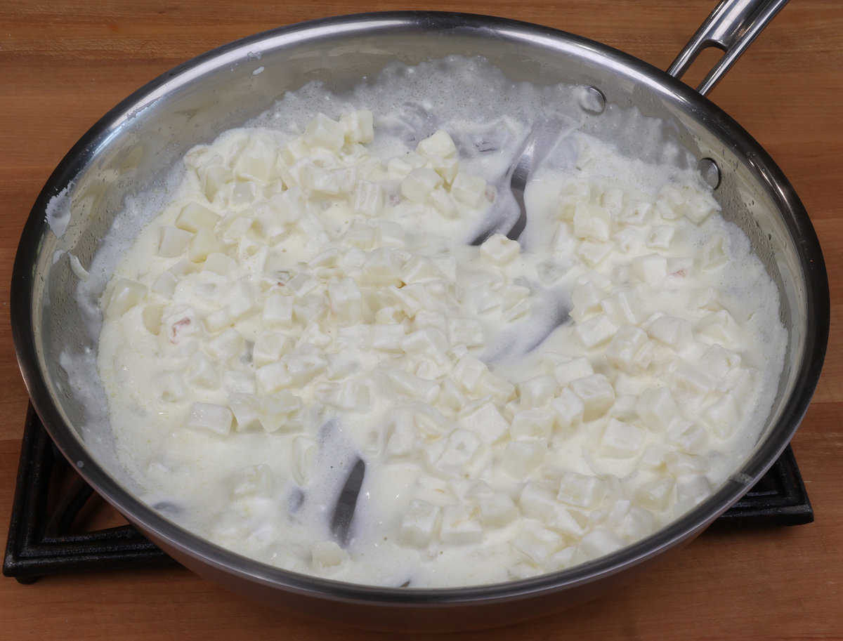 diced potatoes in a cream sauce in a pan.