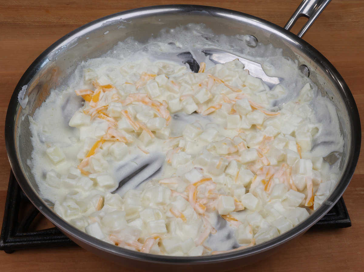 cheesy potato sauce in a skillet.