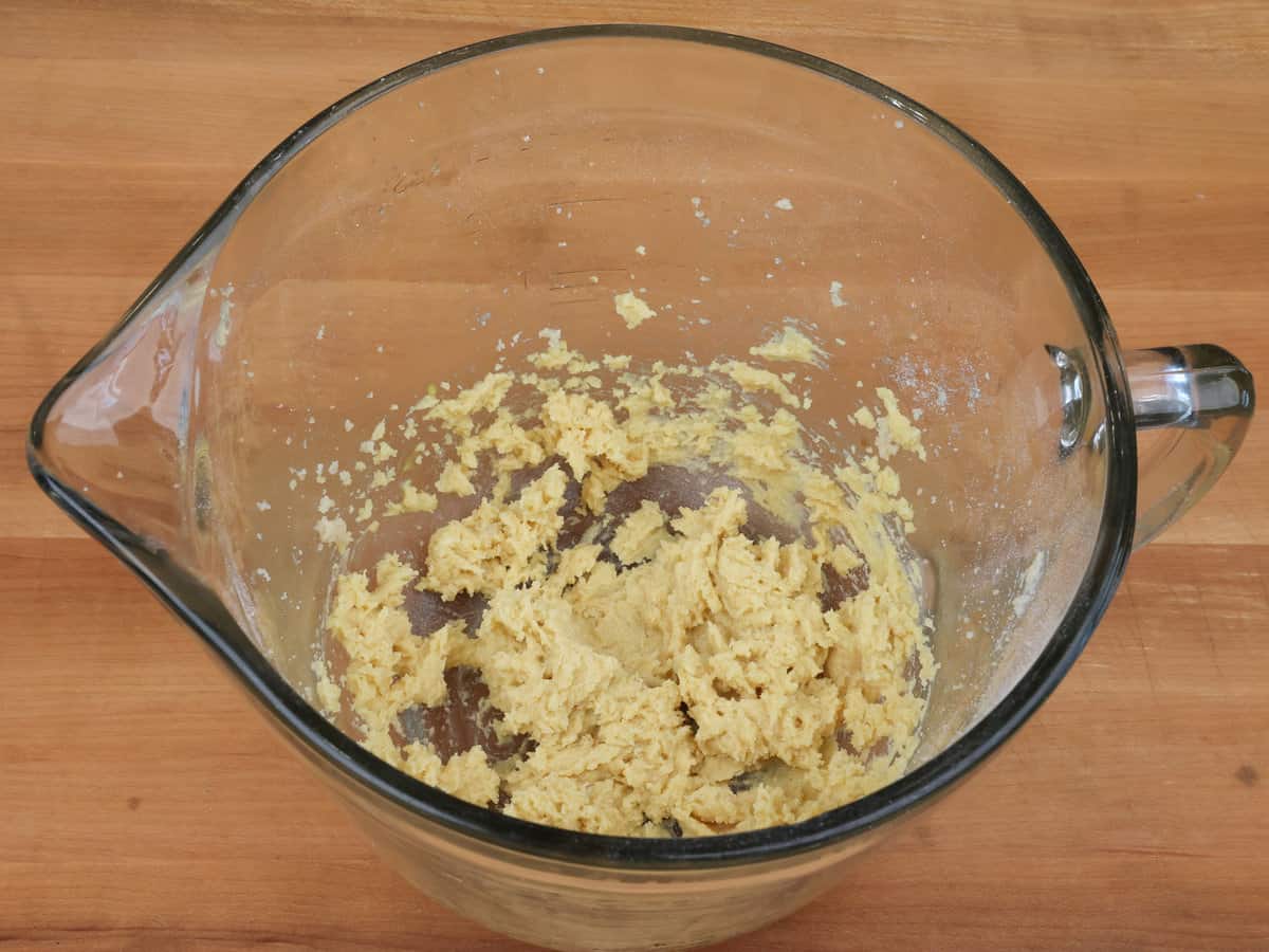 an egg yolk, vanilla, butter and sugar blended together in a mixing bowl.