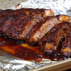 6 barbecued baby back ribs on a baking sheet