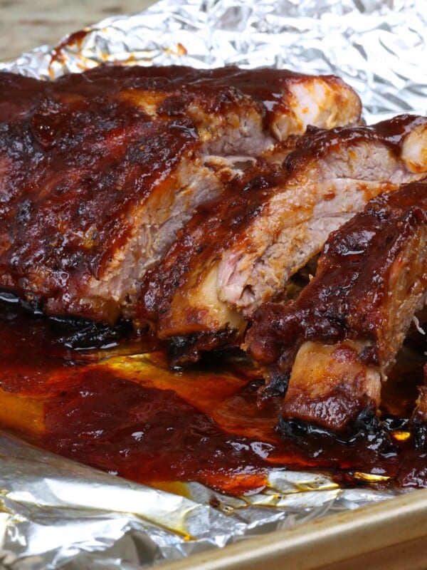6 barbecued baby back ribs on a baking sheet