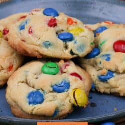 five M&M cookies on a blue plate.