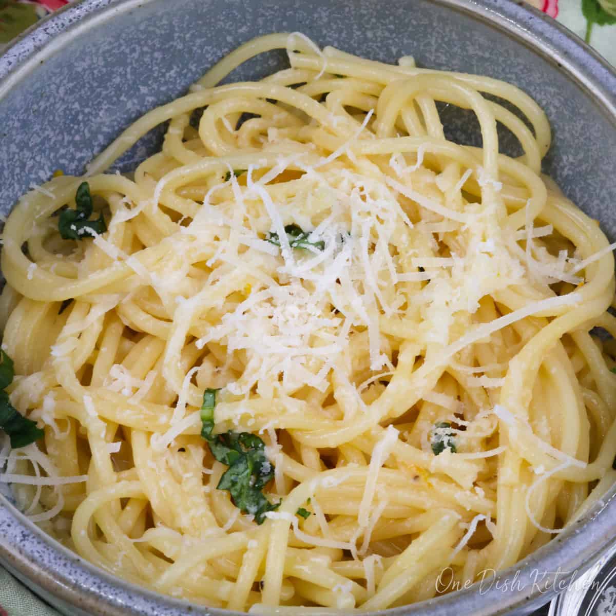 a bowl of pasta al limone topped with parmesan cheese.