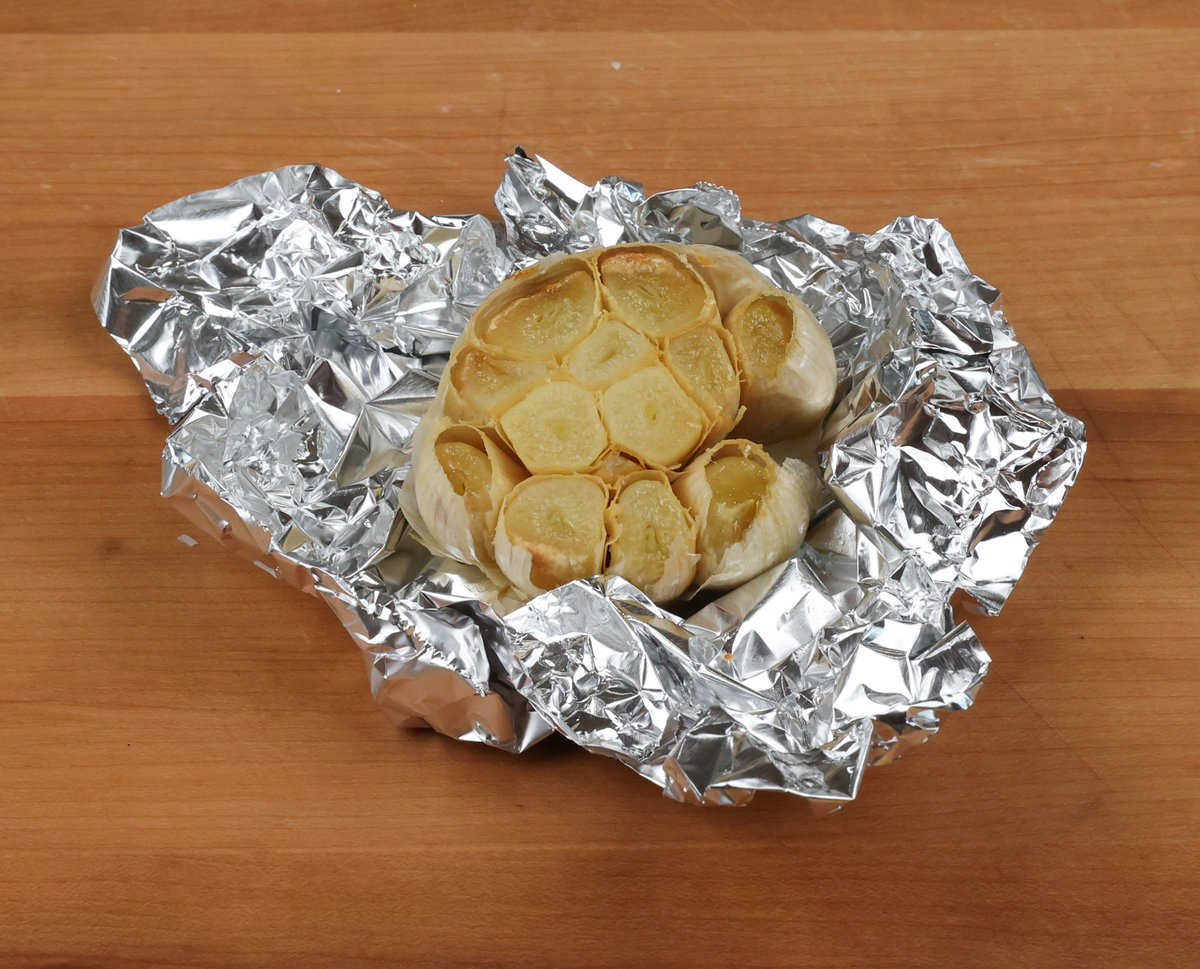 one head of roasted garlic on a sheet of aluminum foil.