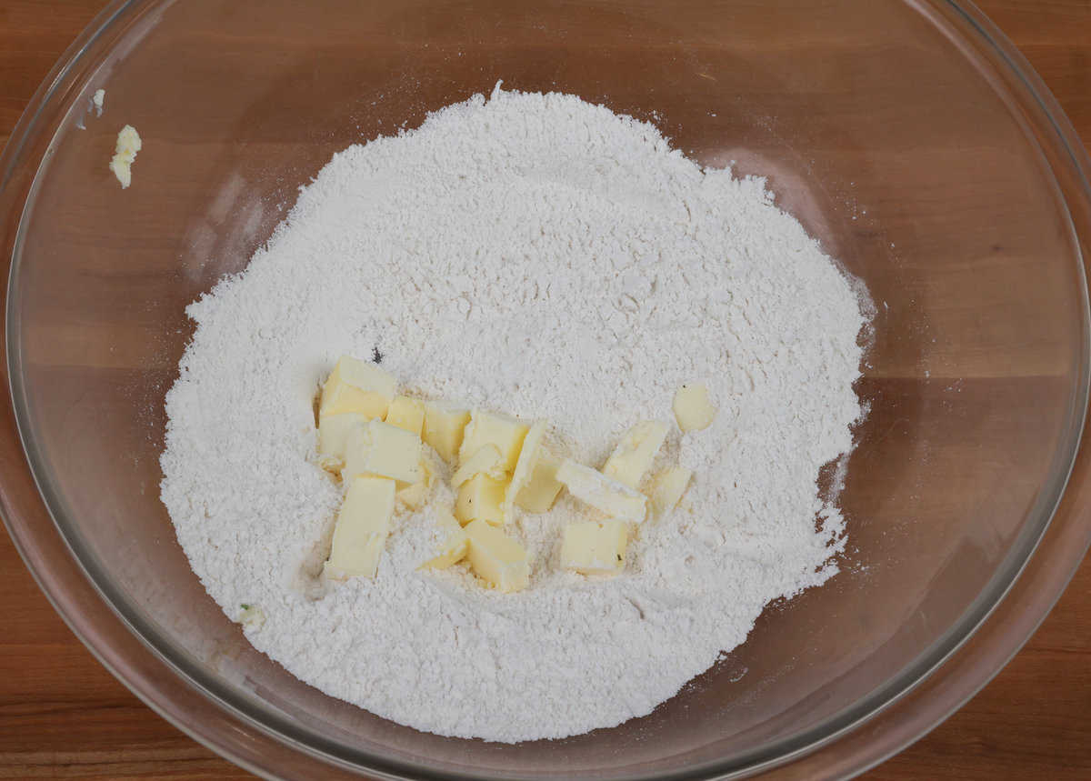 flour, baking powder, baking soda, sugar, salt, and cubed butter in a mixing bowl.