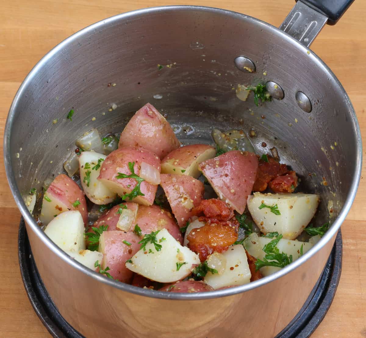 warm german potato salad in a pot on the stove.