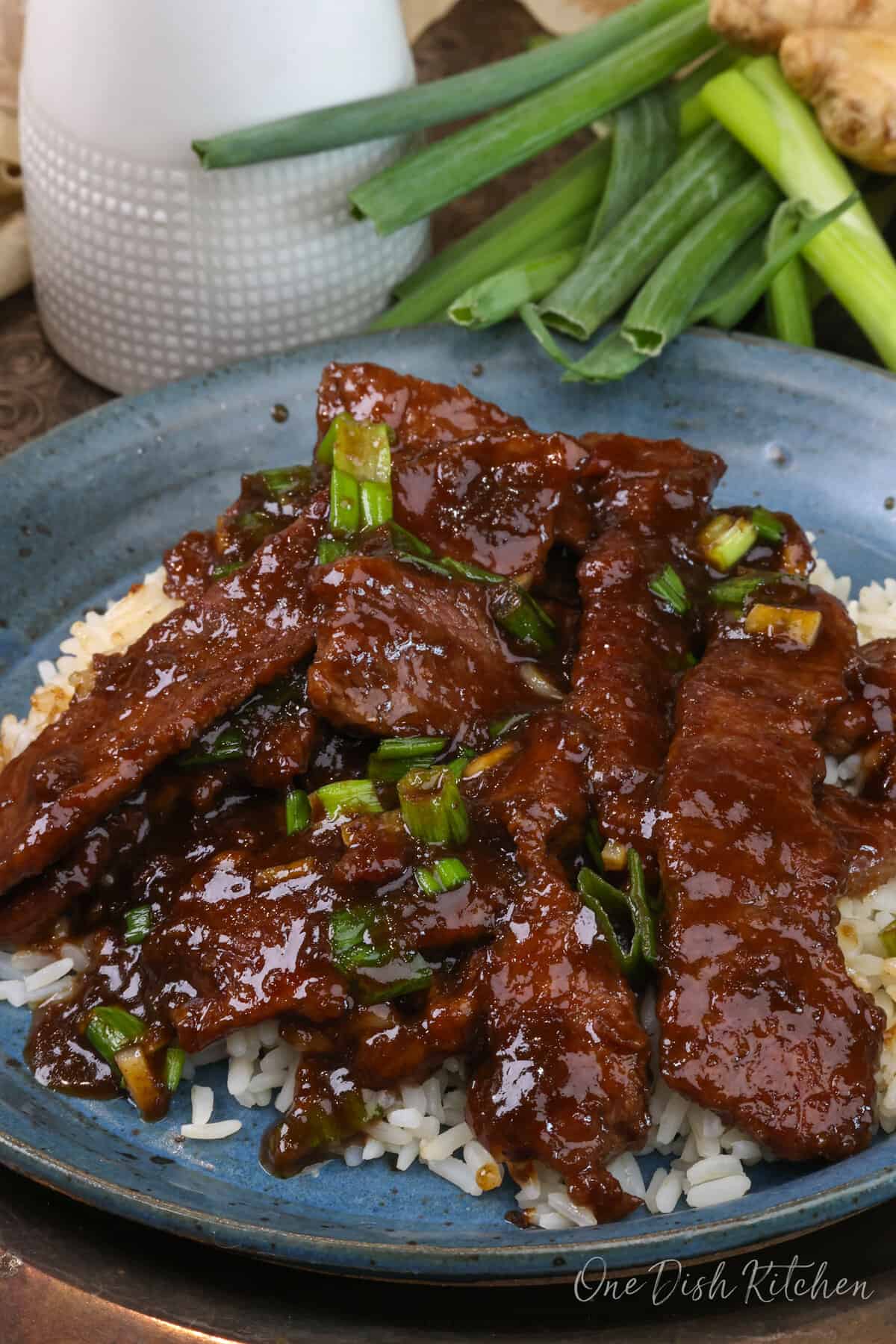 Mongolian Beef over rice on a blue plate.