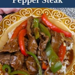 a gold plate filled with pepper steak.