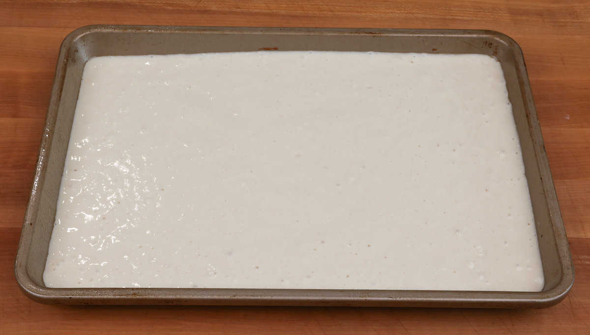 pancake batter spread evenly on a rimmed sheet pan.