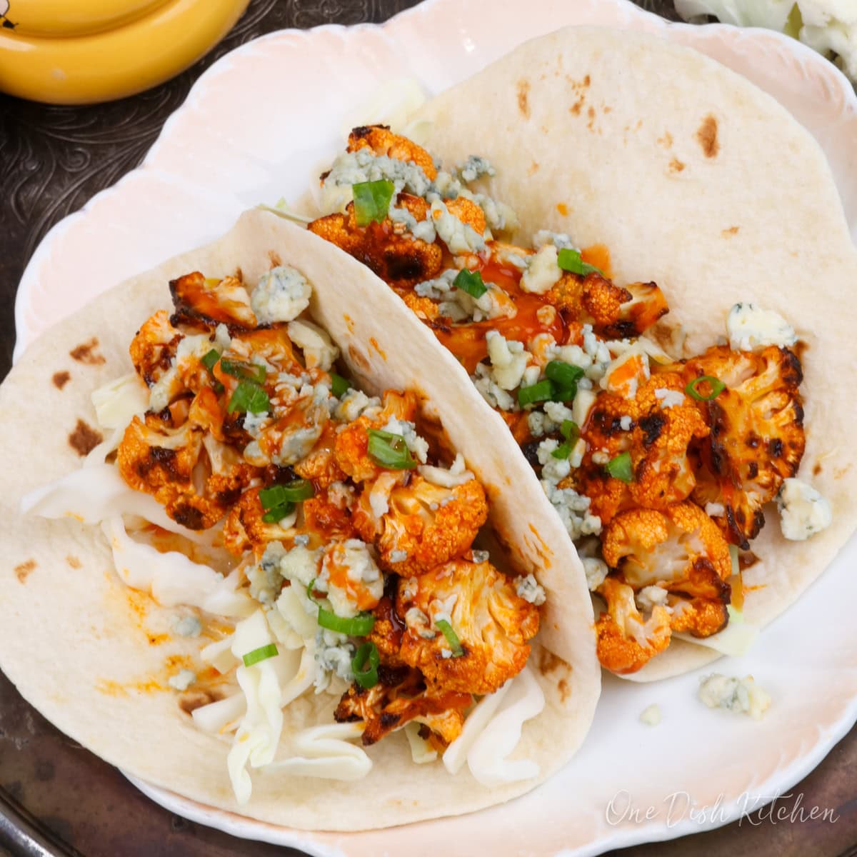crispy buffalo cauliflower tacos on a plate.