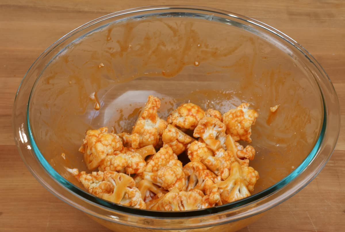 a big bowl of cauliflower florets tossed in buffalo sauce.