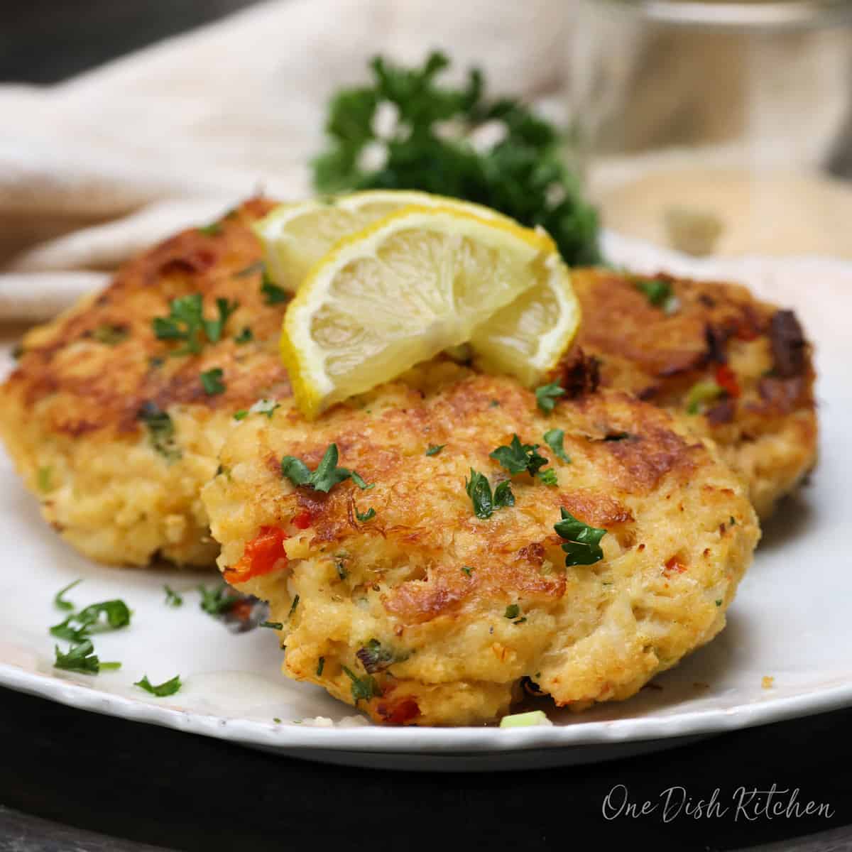 crab cakes topped with lemon juice on a plate.