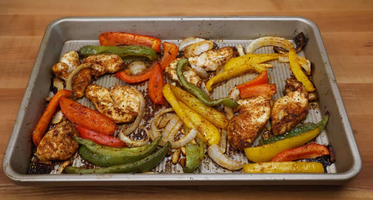 chicken fajitas and vegetables on a sheet pan.
