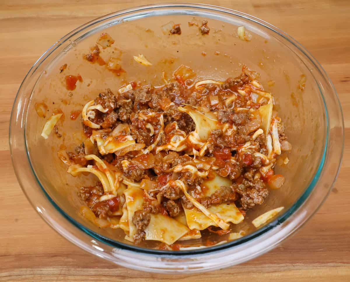 lasagna noodles in a bowl with meat sauce and cheese.