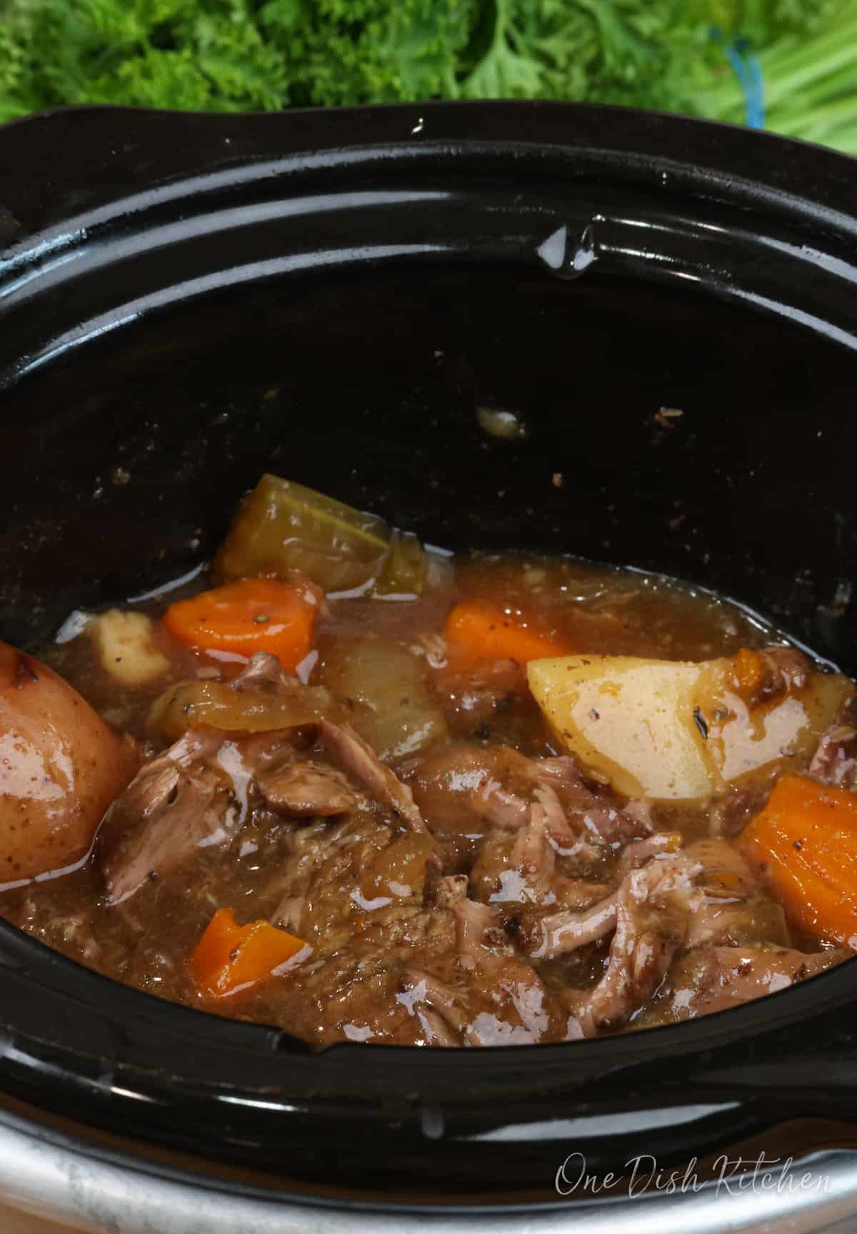 pot roast and vegetables in a slow cooker.
