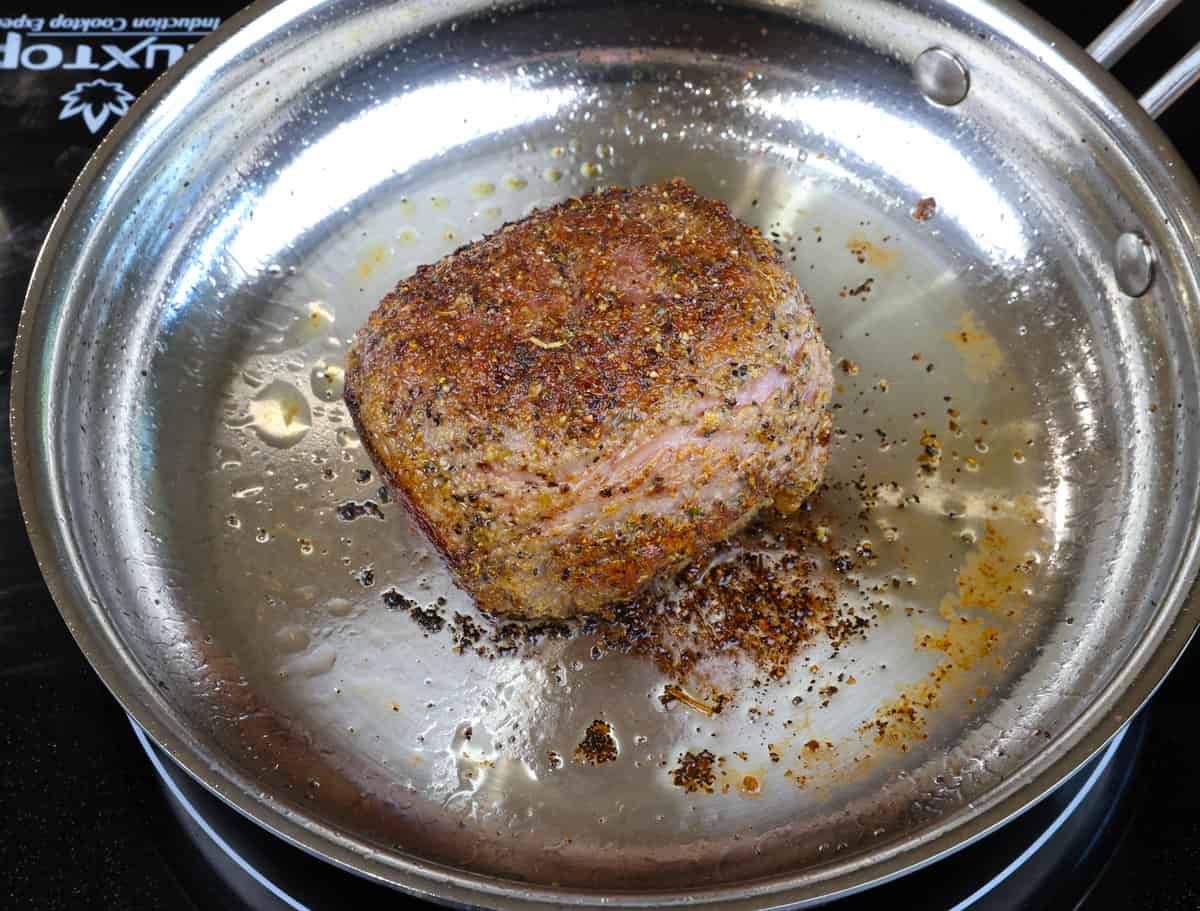 searing a small chuck roast in a skillet.