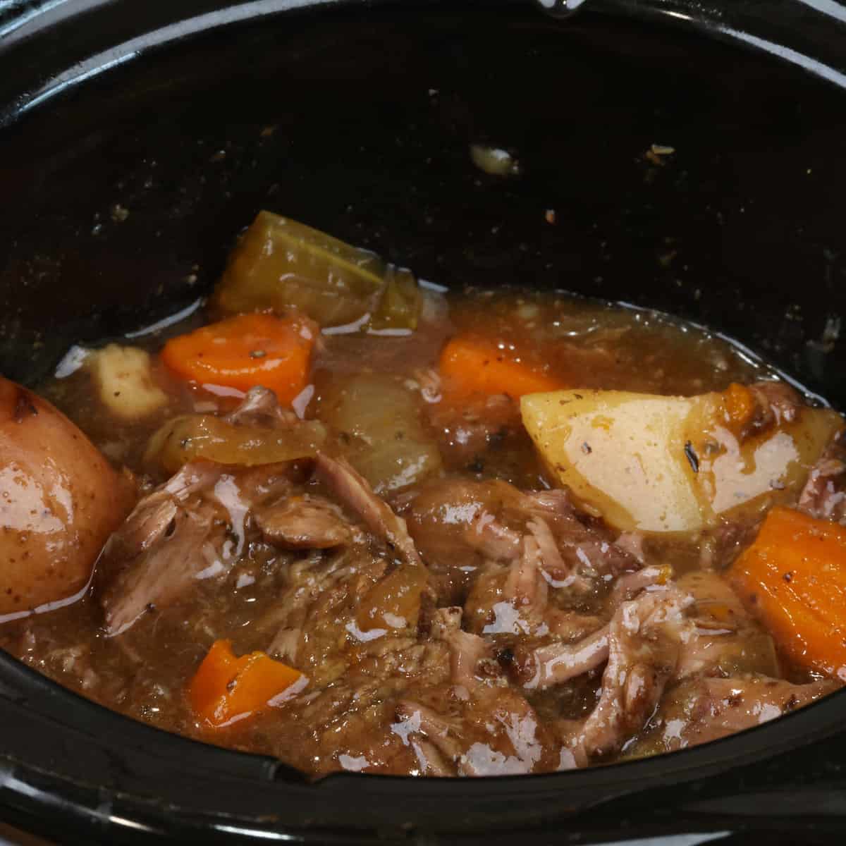 pot roast and vegetables in a slow cooker.