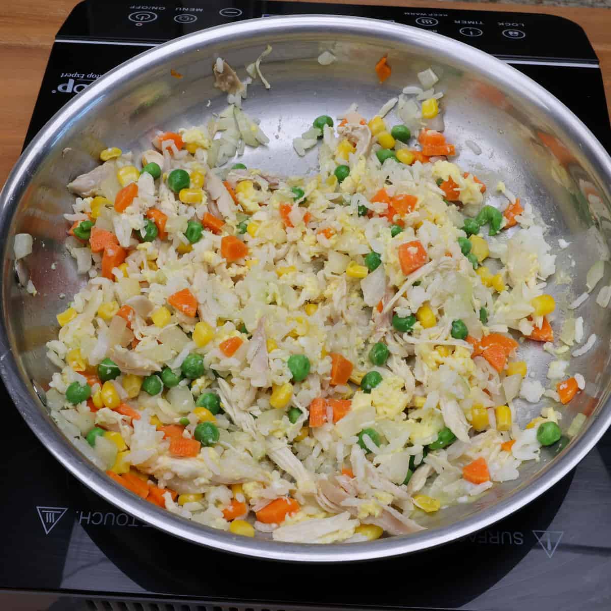 chicken fried rice cooking in a skillet.