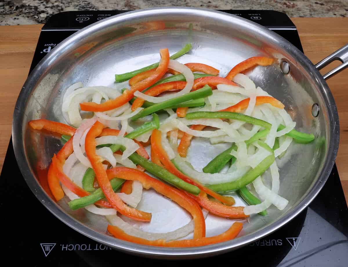 onions and bell peppers in a skillet.