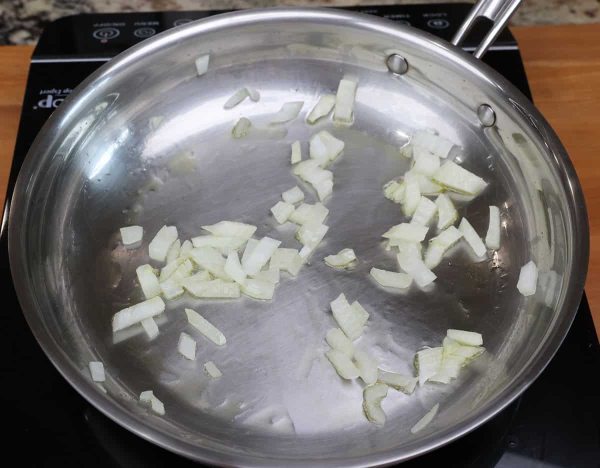 chopped onions cooking in a skillet.