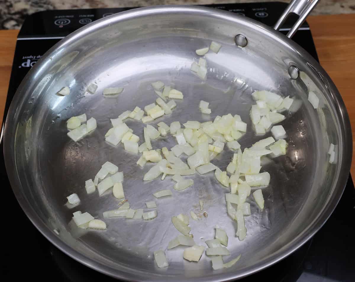 onions and garlic cooking in a skillet.