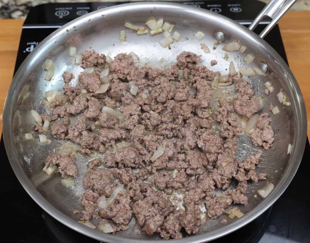 ground beef and italian seasoning cooking in a skillet.