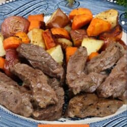steak, potatoes, and carrots on a blue plate.